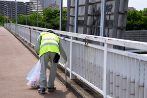 写真：歩道橋でごみを拾う様子