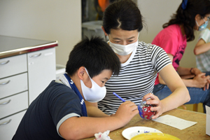 写真：風鈴に絵付けをする様子