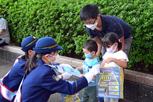 写真：啓発グッズを渡す一日警察署長たち