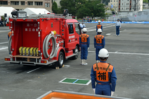 写真：消防ポンプ車で準備をする消防団員