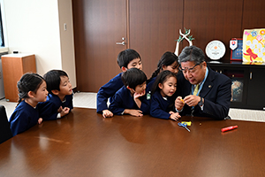 写真:市長と園児が楽しく折り紙を折る様子